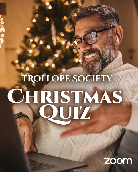 a man sitting in front of a Christmas tree using a laptop