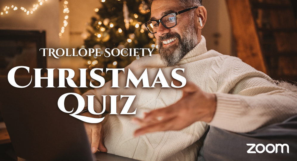 a man sitting in front of a Christmas tree using a laptop